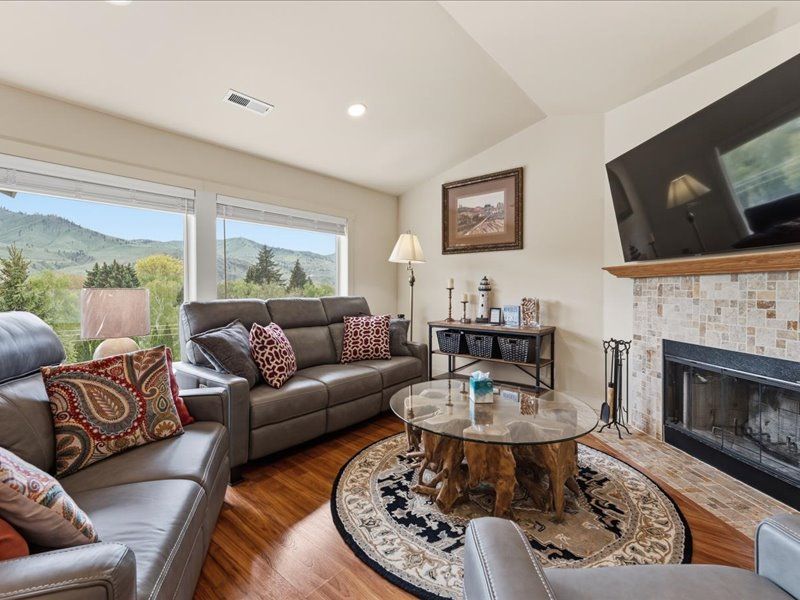 Mountain views frame your cozy living space, where plush leather seating and a warm fireplace invite you to unwind. Enjoy peaceful moments with nature just outside your windows.